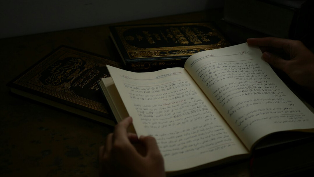 Close-up of hands writing research notes in a notebook